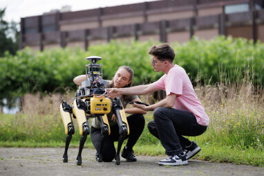 Junge Studierende arbeiten bei einer Gruppenarbeit im Bereich Robotik zusammen